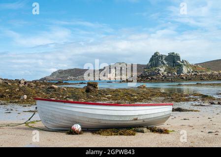 Ein rot-weißes Holzboot am Strand von Kitchen Porth, Bryher, Isles of Scilly Stockfoto