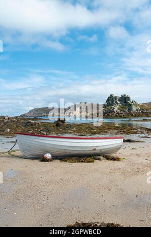 Ein rot-weißes Holzboot am Strand von Kitchen Porth, Bryher, Isles of Scilly Stockfoto