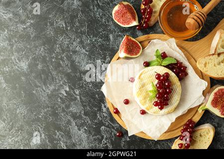 Konzept von leckeren Speisen mit gegrilltem Camembert auf schwarzem rauchigen Hintergrund. Stockfoto