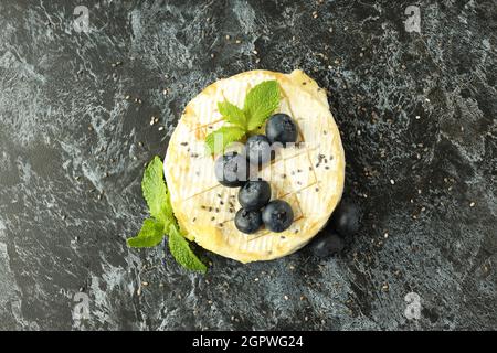 Schmackhafter gegrillter Camembert auf schwarzem rauchigen Hintergrund. Stockfoto
