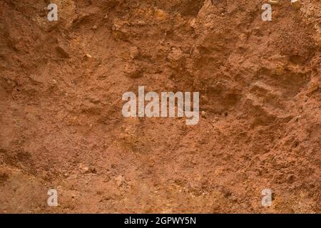 Abstrakte Seitenansicht von Carving Mountain Earth Boden, gelb oder rot Ton, oxidierte und sehr fruchtbaren Boden roten Ton Hintergrund, Textur, Vollformat Stockfoto