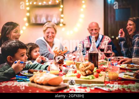 Multi Generation große Familie mit Spaß auf weihnachtsessen Party - Winterurlaub Weihnachten Konzept mit Großeltern und Kinder essen zusammen zu Hause Stockfoto