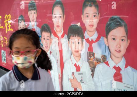 Ein Leuchtkastenposter mit Jugendlichen in roten Schals, um das Lesen in Peking, China, zu fördern. 30-Sep-2021 Stockfoto