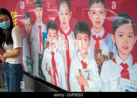 Ein Leuchtkastenposter mit Jugendlichen in roten Schals, um das Lesen in Peking, China, zu fördern. 30-Sep-2021 Stockfoto