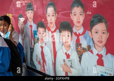 Ein Leuchtkastenposter mit Jugendlichen in roten Schals, um das Lesen in Peking, China, zu fördern. 30-Sep-2021 Stockfoto