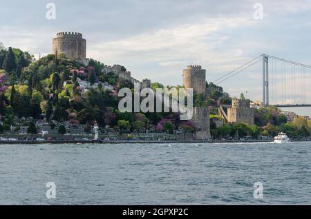 Die Festung von Rumeli Hisari vor dem Hintergrund einer Fatih Sultan Mehmet Brücke über den Bosporus in Istanbul, Türkei. Stockfoto