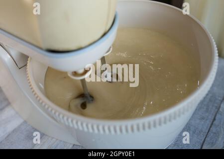 Schritt für Schritt der Prozess der Herstellung von Sauerrahm Pie Teig. Alle Zutaten werden in die Rührschüssel gegeben. Der Teig wird mit dem Schneebesen geknetet. Backkonzept. Stockfoto