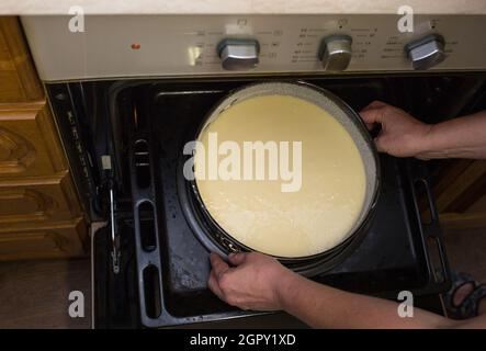 Schritt für Schritt der Prozess der Herstellung von Sauerrahm Pie Teig. Weibliche Hände legen fertigen rohen Teig in eine vorbereitete Auflaufform in einen heißen Ofen. Backkons Stockfoto