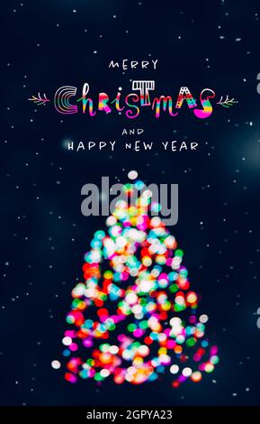 Frohe Weihnachten und ein glückliches Neues Jahr Gruß mit Weihnachtsbaum aus bunten unfokussigen Weihnachtslichtern bei schniebendem Abend und lustigen Schriftzügen Stockfoto