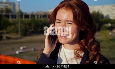 Eine junge Frau mit Flecken im Gesicht telefoniert über der Straße Stockfoto