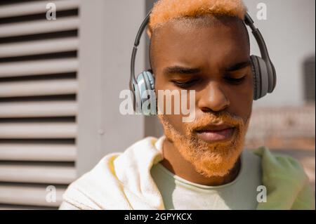 Ein dunkelhäutiger bärtiger junger Mann mit Kopfhörern Stockfoto