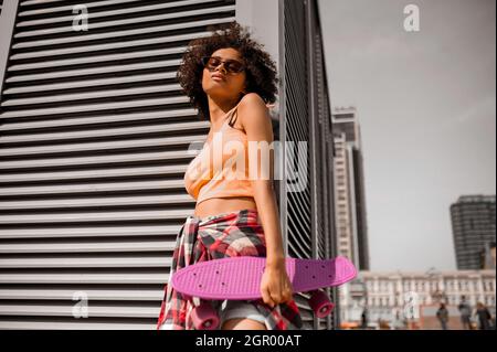 Nette und niedliche junge Frau in orange Top sieht gut aus Stockfoto