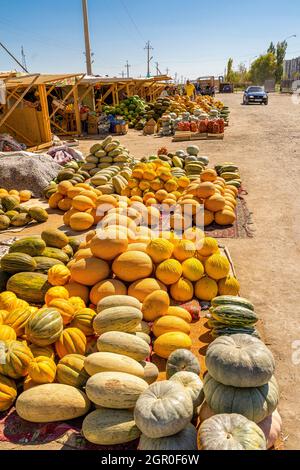 Melonen und Kürbisse, die am Boden verkauft werden, werden auf dem saisonalen Outdoor-Markt in Kyzyl-Orda, Kasachstan, Zentral- und Asien ausgestellt Stockfoto