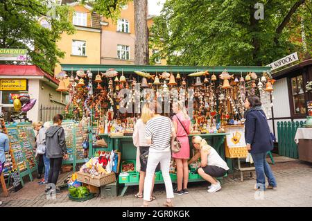 POZNAN, POLEN - 30. Mai 2016: Die Menschen, die auf einer Hauptstraße gehen, und die Straßenreinigung, die eine Pause im Stadtzentrum machen. Stockfoto