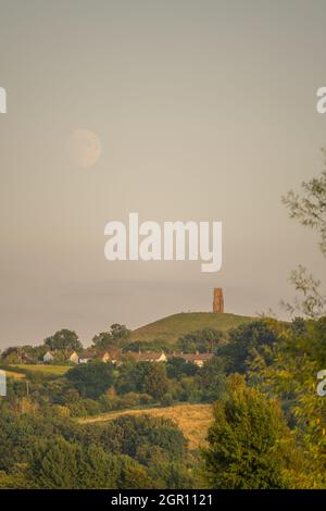 Glastonbury Tor von den Mooren bei Sonnenuntergang. Mit einem aufgehenden Vollmond. Stockfoto