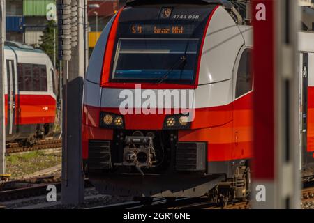 Roter elektrischer Personenzug im Grazer Bahnhof im Sommer sonniger frischer Morgen Stockfoto