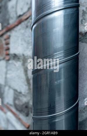 Spiralförmiges Metallrohr an der Wandkante Stockfoto