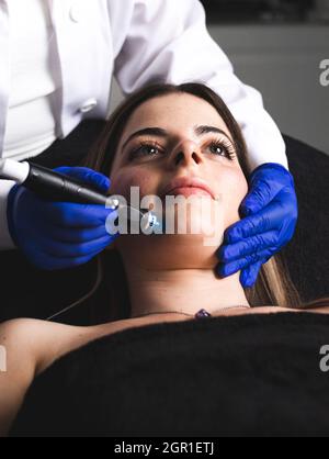 Eine junge Frau, die ihr Gesicht in einer ästhetischen Klinik putzt Stockfoto