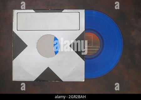 Gealtertes schwarzes Papiercover und blaue Vinyl-LP-Platte isoliert auf rostigen Hintergrund Stockfoto