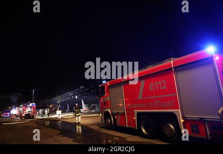 Stuttgart, Deutschland. September 2021. Feuerwehrleute stehen in einem Depot für Busse. Am Abend brannte im Busdepot des Stuttgarter Verkehrsvereines. Mehrere Fahrzeuge sind in Brand. Quelle: Tom Weller/dpa/Alamy Live News Stockfoto