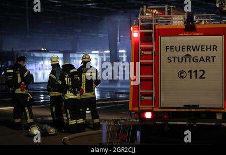 Stuttgart, Deutschland. September 2021. Feuerwehrleute stehen in einem Depot für Busse. Am Abend brannte im Busdepot des Stuttgarter Verkehrsvereines. Mehrere Fahrzeuge sind in Brand. Quelle: Tom Weller/dpa/Alamy Live News Stockfoto