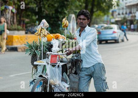 POKHARA - NEPAL, 30. MAI 2016: Ein Fruchtsaftverkäufer zieht sein Fahrrad mit Früchten beladen Stockfoto