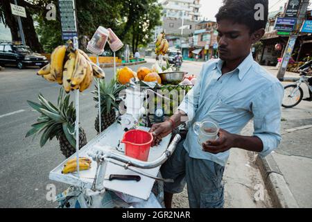 POKHARA - NEPAL, 30. MAI 2016: Ein nicht identifizierter Fruchtsaftverkäufer macht Saft Stockfoto