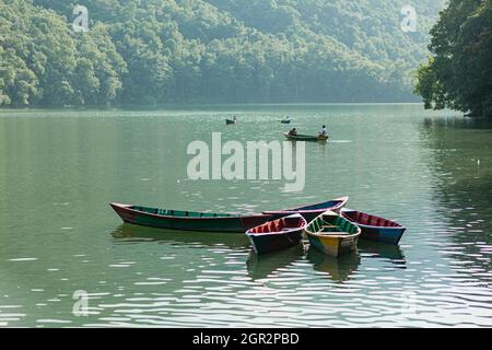 POKHARA - NEPAL, 30. MAI 2016: Schwimmende Boote mit Touristen auf dem See von Fewa Stockfoto