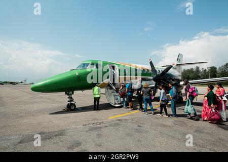 POKHARA - NEPAL, 30. MAI 2016: Menschen steigen am Flughafen Pokhara in ein Flugzeug ein Stockfoto