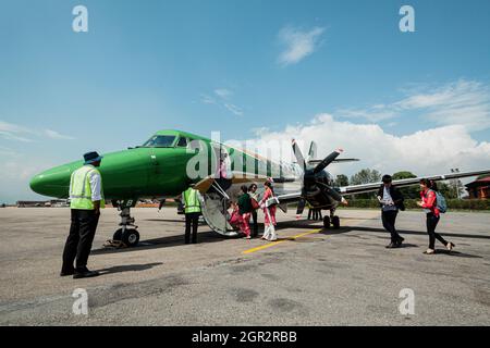 POKHARA - NEPAL, 30. MAI 2016: Menschen besteigen ein Flugzeug von Yeti Airlines am Flughafen Pokhara Stockfoto