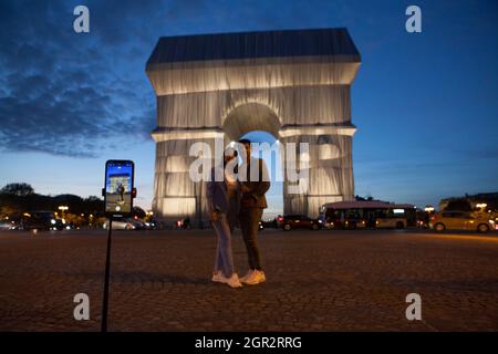 Paris, Frankreich, 30. September 2021: Der Arc de Triomphe in Paris, wie von den Künstlern Christo und Jeanne-Claude geplant in Silbergewebe gewickelt, zieht einen stetigen Strom von Touristen an. An diesem Wochenende wird der Place Charles de Gaulle, der den Bogen umgibt, für den Verkehr gesperrt, was eine sicherere Sicht auf die Sehenswürdigkeiten ermöglicht als für diejenigen, die aus der Mitte der Boulevards, die vom Kreisverkehr ausstrahlen, einige Aufnahmen gemacht haben. Die Kunstinstallation wird ab Montag, dem 4. Oktober, demontiert, damit die Feierlichkeiten zum Waffenstillstandstag wie gewohnt stattfinden können. Anna Watson/Alamy Live News Stockfoto