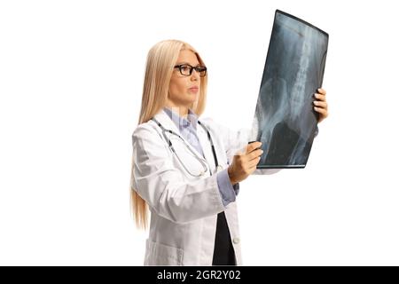 Junge Ärztin, die einen auf weißem Hintergrund isolierten Röntgenscan anschaut Stockfoto