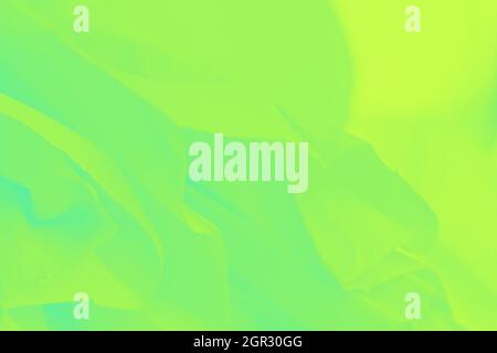 Grün gelb Glanz Neonfarbe fliegende Stoff Textur, abstrakt verschwommener Hintergrund Stockfoto