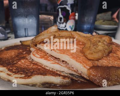 Nahaufnahme von flauschigen Pfannkuchen mit karamellisierten Bananen darauf Stockfoto