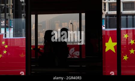 Hongkong, Hongkong. September 2021. Vor dem Nationalfeiertag laufen die Menschen bei Tsim Sha Tsui an China- und Hongkong-Flaggen vorbei.Angesichts der Pandemie des COVID 19 und des nationalen Sicherheitsgesetzes, das gegen die demokratische Bewegung Hongkongs vorgeht, wurden zahlreiche Flaggen in der Stadt als Propaganda zur Feier des 72. Nationaltages Chinas eingesetzt. Kredit: SOPA Images Limited/Alamy Live Nachrichten Stockfoto