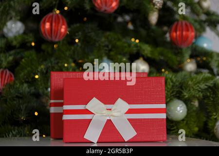 Weihnachtsgeschenke.Überraschungen und Geschenke für die Winterferien. Rote Boxen auf Weihnachtsbaum Hintergrund.Weihnachten und Neujahr Stockfoto