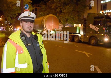 München, Deutschland. September 2021. Michael Eichner von der Verkehrssteuerung begleitet ein Schwerlastfahrzeug mit einem großen Silo zum KWK-Werk München Süd. Der Transport startete nachts auf der Route Ingolstädter Straße in Richtung Leopoldstraße durch das Stadtzentrum, über die Sonnenstraße in Richtung Theresienhöhe, die Brudermühlstraße zum Blockheizkraftwerk in der Schäftlarnstraße. Quelle: Felix Hörhager/dpa/Alamy Live News Stockfoto