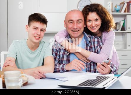 Glückliche Familie, die mit Dokumenten arbeitet Stockfoto