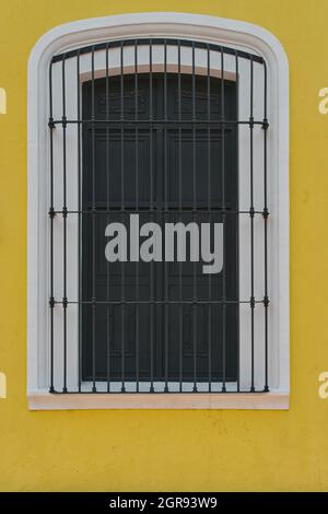 Fenster mit einer gelben Fassade und schwarzen Türen Stockfoto
