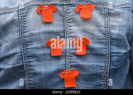 Orangefarbene Trikot-Day-Symbole auf einer Jacke zu Ehren der Überlebenden indigener Wohnschulen in Kanada Stockfoto