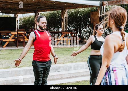Junge lateinamerikaner im Yoga-Kurs machen Atemübungen mit einem Lehrer im Freien in Mexiko-Stadt Stockfoto