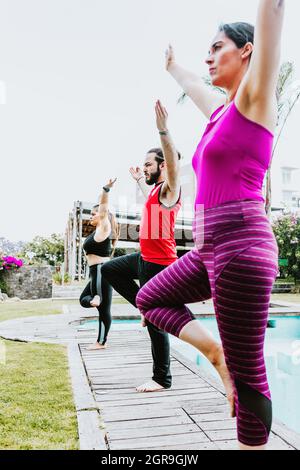 Gruppe von lateinern, die Yoga-Haltungen praktizieren, stehen in Lateinamerika im Freien Stockfoto