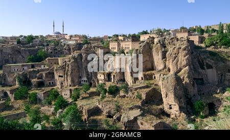 Ländliche Stadt des traditionellen Landes in der Türkei Moschee von Guzelyurt und Felsen geschnitten Höhlenhäuser in den typischen vulkanischen Felsen von Kappadokien geschnitzt Stockfoto