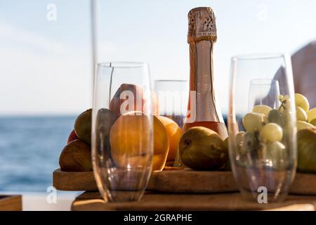Obstschale und Flasche Champagner für ein romantisches Date auf einer Yacht Stockfoto