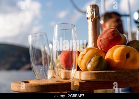 Obstschale und Flasche Champagner für ein romantisches Date auf einer Yacht Stockfoto