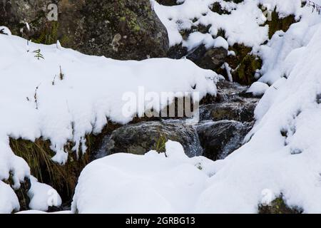 Flusswasser im Schnee in den Bergen Georgiens Stockfoto