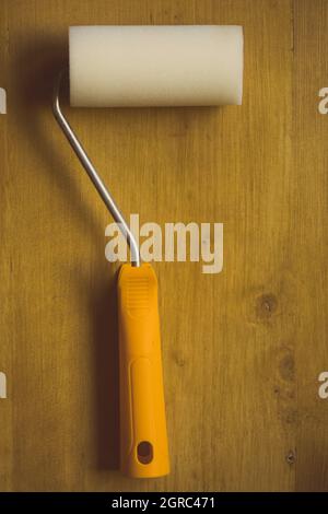 Nahaufnahme einer Farbwalze auf einem Holzhintergrund. Stockfoto