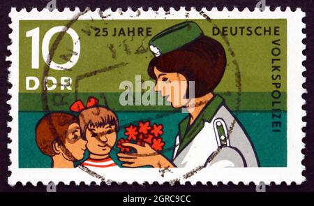 DDR - UM 1970: Eine in der DDR gedruckte Briefmarke zeigt junge Pioniere, die der Polizeifrau gratulieren, 25. Jahrestag der Volkspolizei, um 1970 Stockfoto