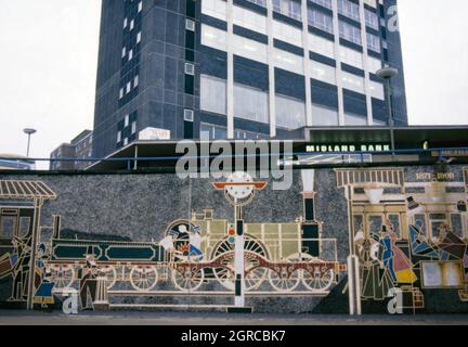 Eine Ansicht des ursprünglichen ‘History of Snow Hill’, ein Wandgemälde von Kenneth Budd aus dem Jahr 1968, das 1978 im Queensway des St Chad, Birmingham, England, Großbritannien, gelegen wurde. Das Wandgemälde feierte die Geschichte des Bahnhofs Birmingham Snow Hill und der Great Western Railway, dem Unternehmen, das den Zugverkehr zwischen London Paddington und Snow Hill Betrieb. Das Wandgemälde wurde 2007 zerstört, als das Gebiet sanierte. 2013 hat Kenneth Budds Sohn Oliver Budd das Wandbild in Miniatur in der Nähe neu gestaltet. Dieses Bild stammt von einem alten Amateur-35-mm-Farbtransparenz – einem Vintage-Foto aus den 1970er Jahren. Stockfoto