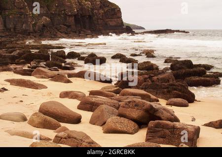 Ein Blick auf die Sandwood Bay, Cape Wrath, Sutherland, Schottland mit dem Meer, den Klippen und den großen Felsen am Strand Stockfoto